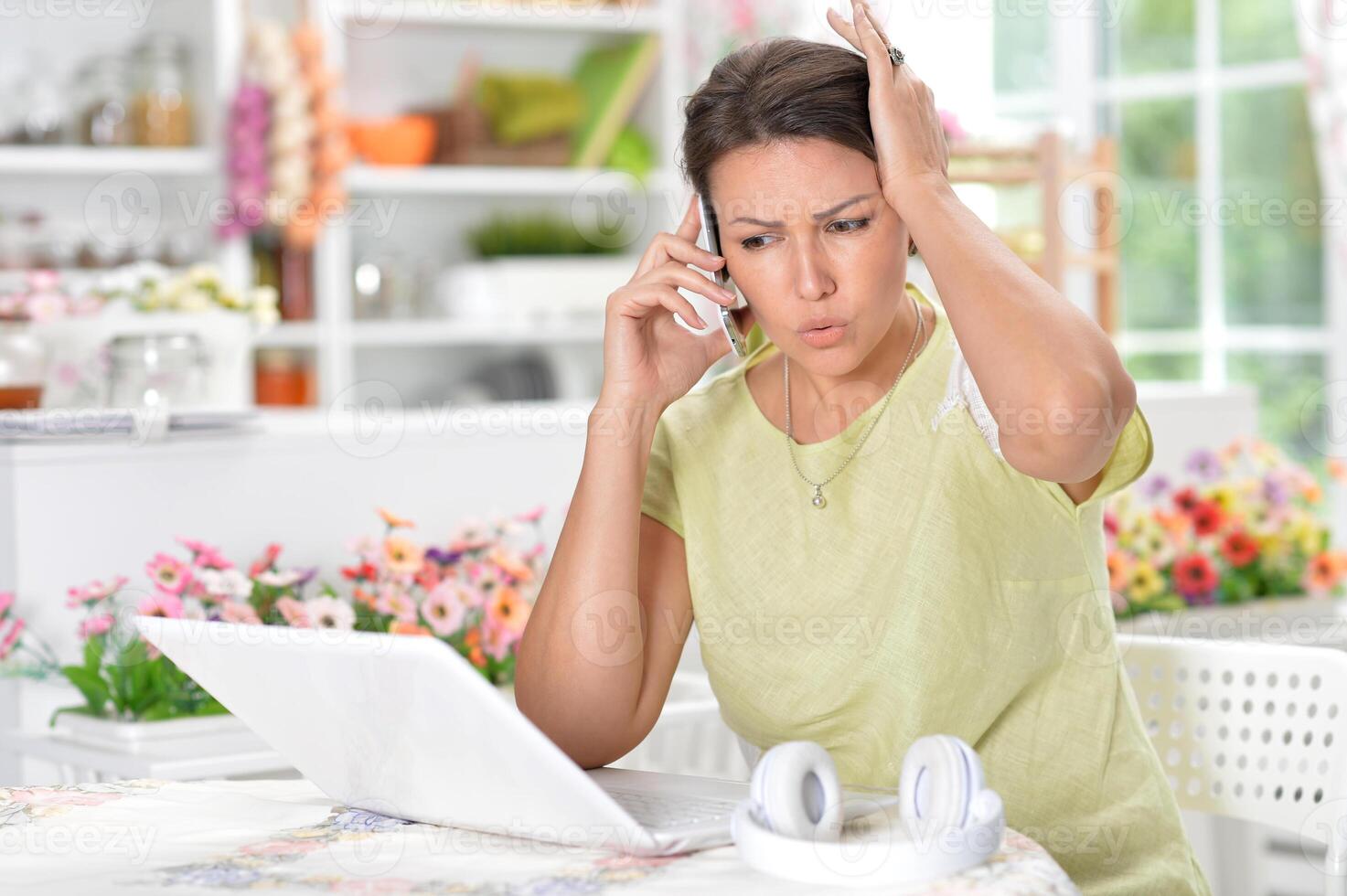 A young emotional girl uses a laptop at home photo