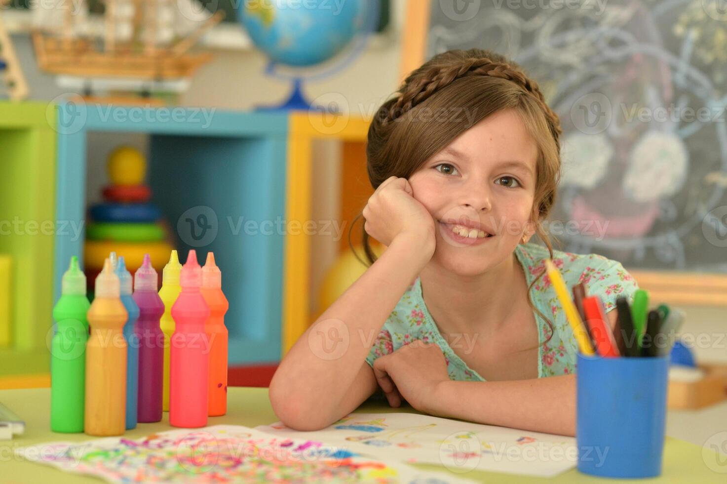 Portrait of cute girl drawing picture at home photo