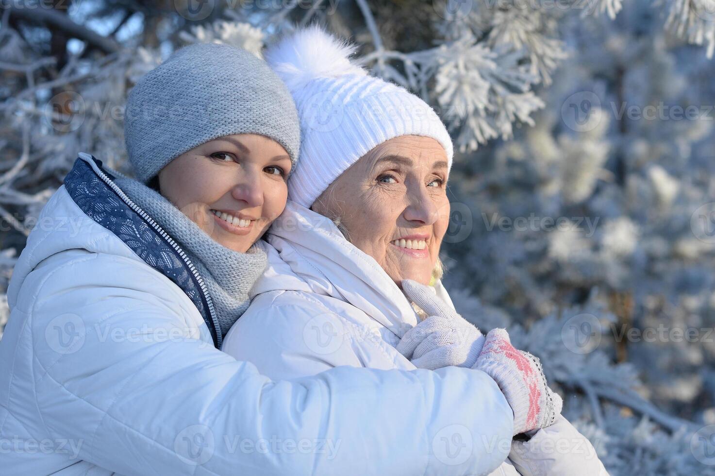 Beautiful elderly woman and her daughter enjoy winter together. photo