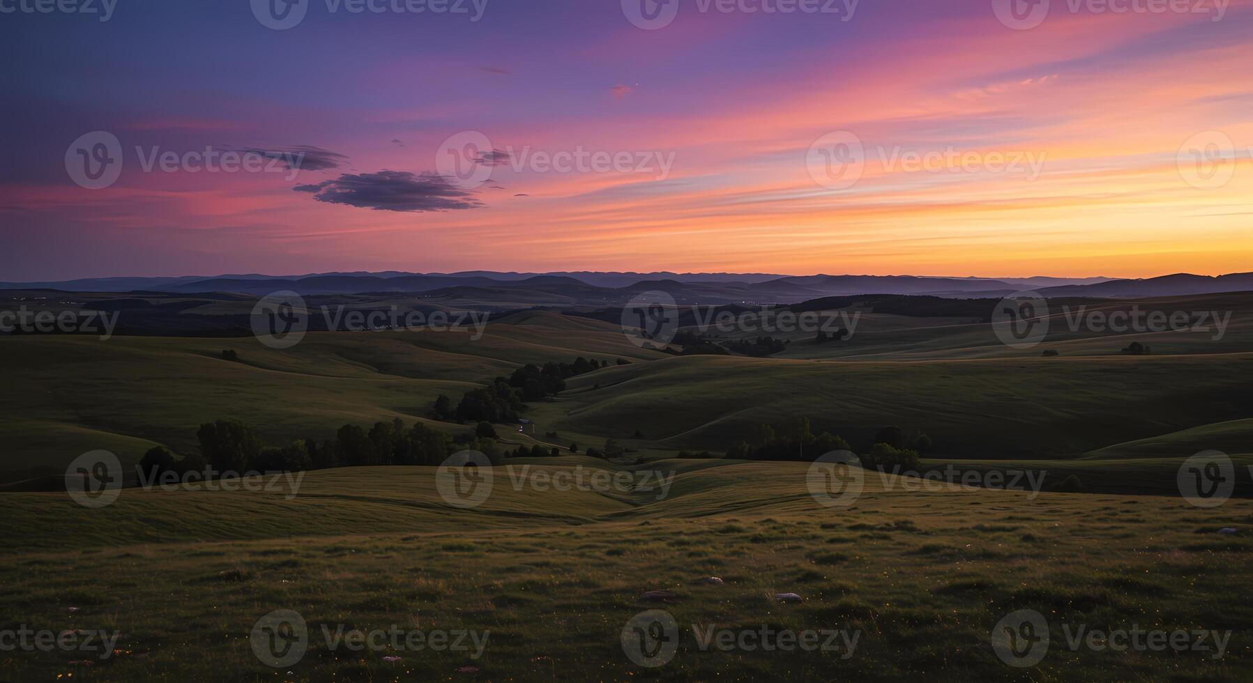 A sunset over a field with a few hills in the background photo