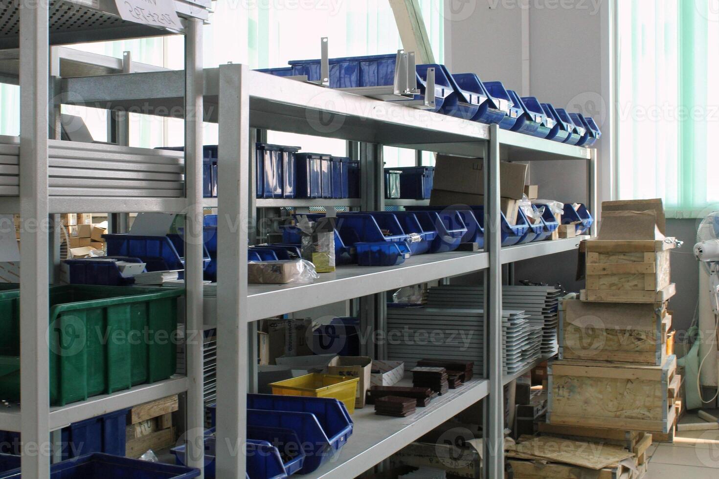 Metal shelf with various storage bins and containers, showcasing organization and storage solutions. Industrial or warehouse setting with a focus on organization and utility photo