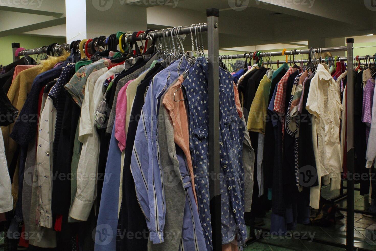 Close-up of rack of colorful clothes hanging in row with variety of textures and styles. Fashion and personal style, diversity of clothing and individual expression. Retail or wardrobe management photo