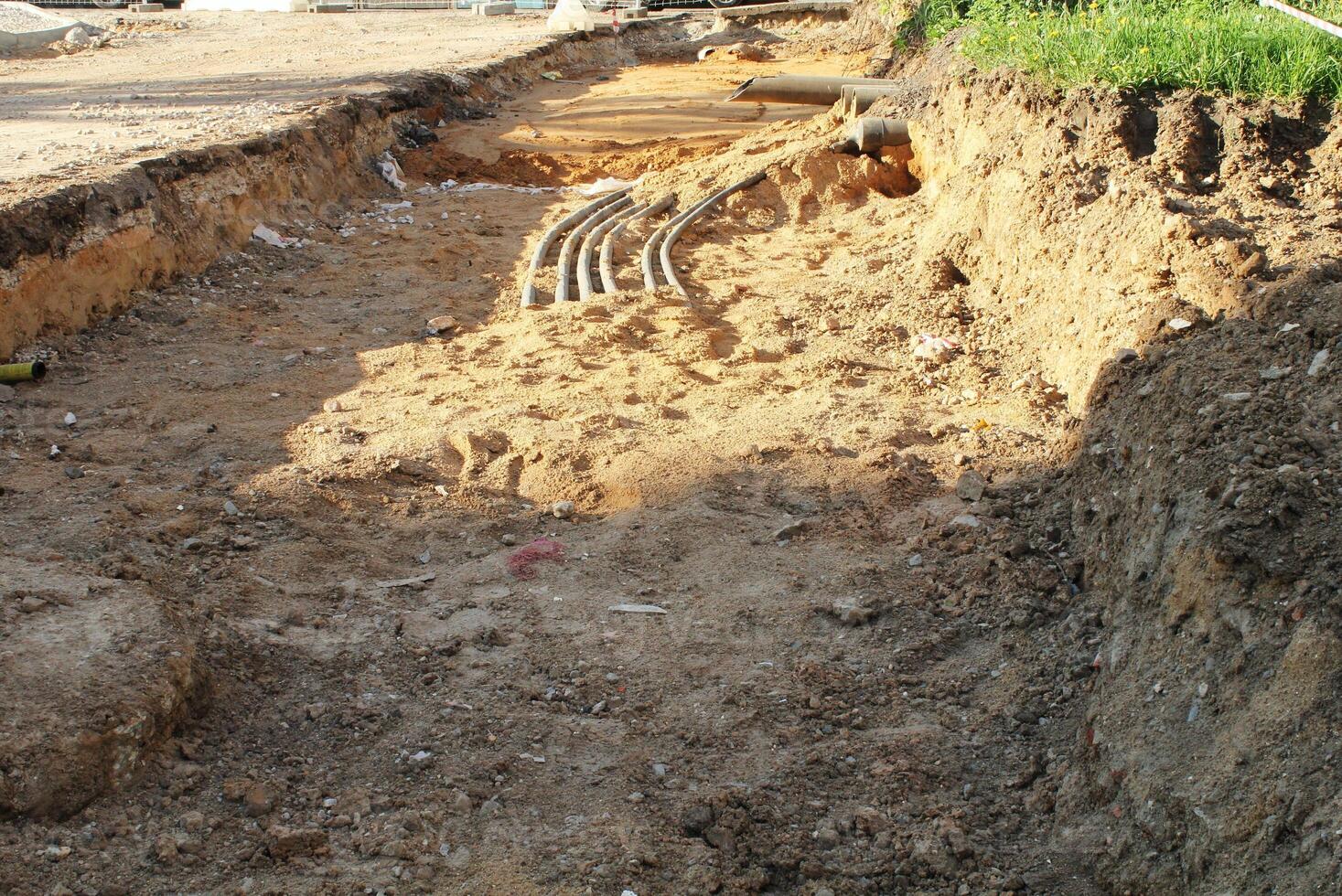 Trench excavation with exposed pipes or cables at a construction site. Earthwork, infrastructure, and urban development concept photo