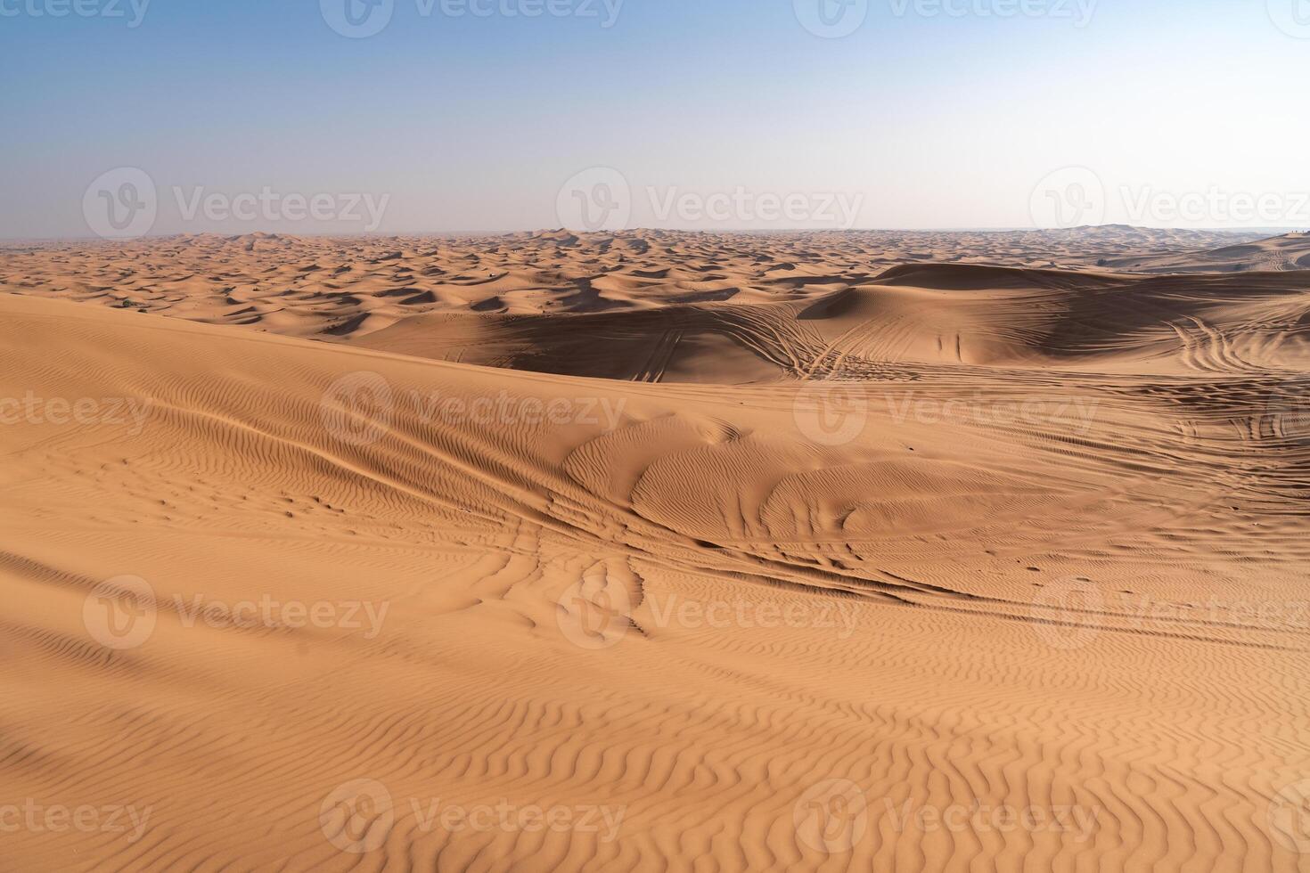 tire marks of off-road vehicles on desert dunes near Dubai during a sunny day photo