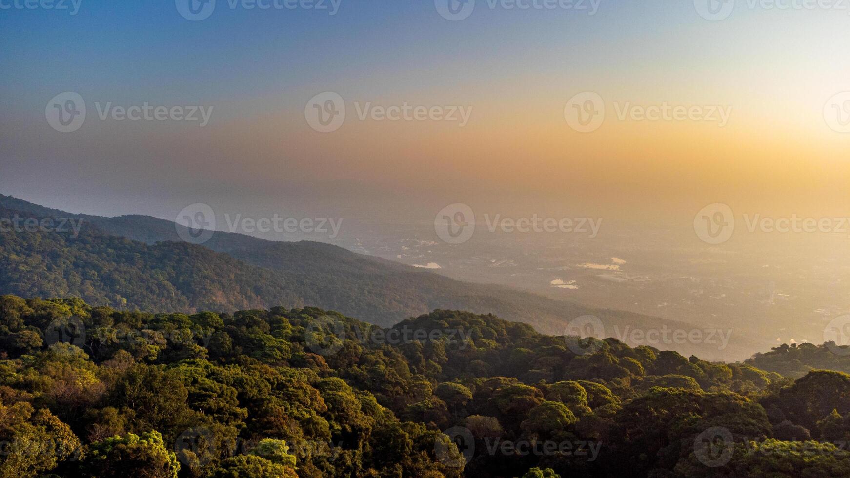Tropical rainforest covering mountain range at sunrise with Chiang Mai in the background photo