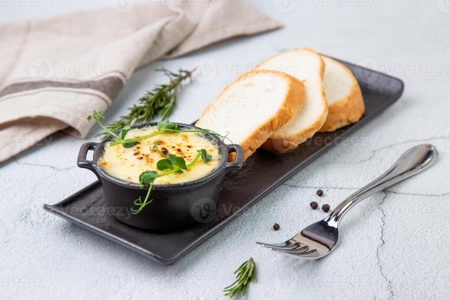Julienne in a mug with pieces of bread side view photo