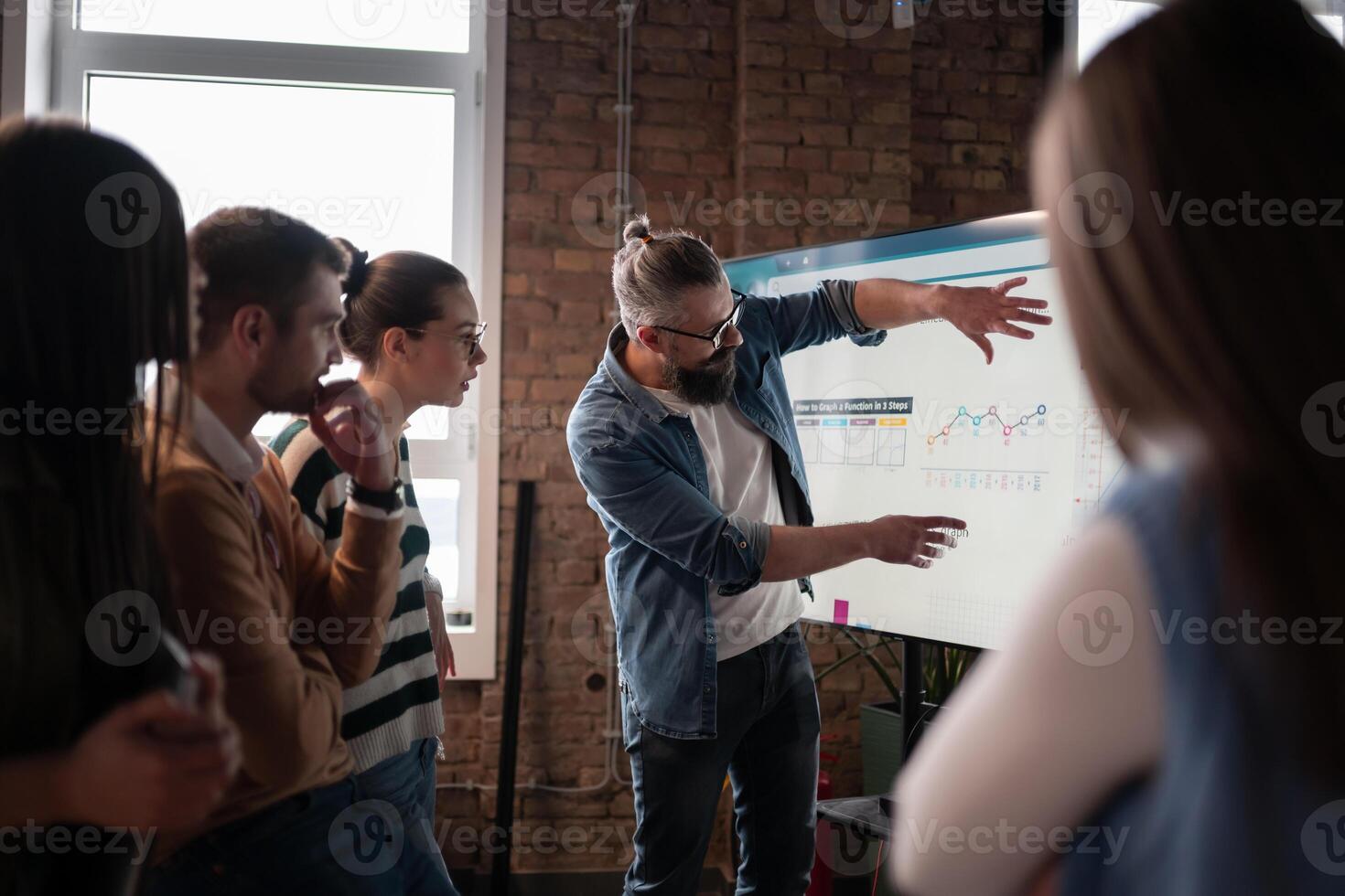 In a sleek glass office space, a team of business professionals engage in lively discussions and exchange strategic ideas, showcasing collaboration and innovation at the heart of modern corporate photo