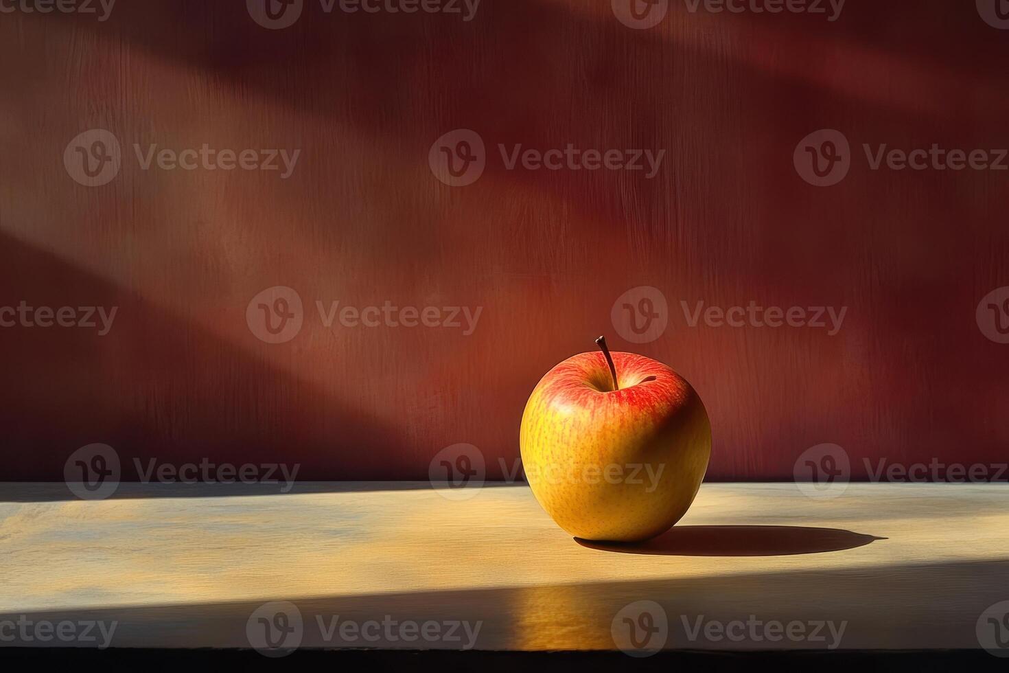 A Single Red and Yellow Apple on a Wooden Surface with Sunbeams photo