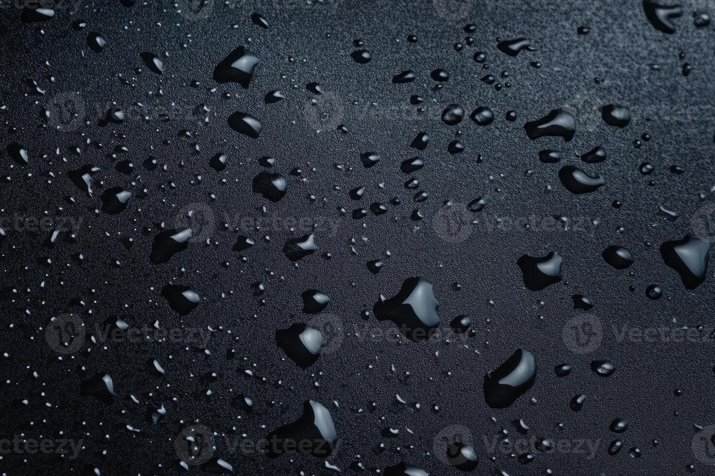 Water droplets on a textured black surface, creating a dark, moody, and reflective pattern photo