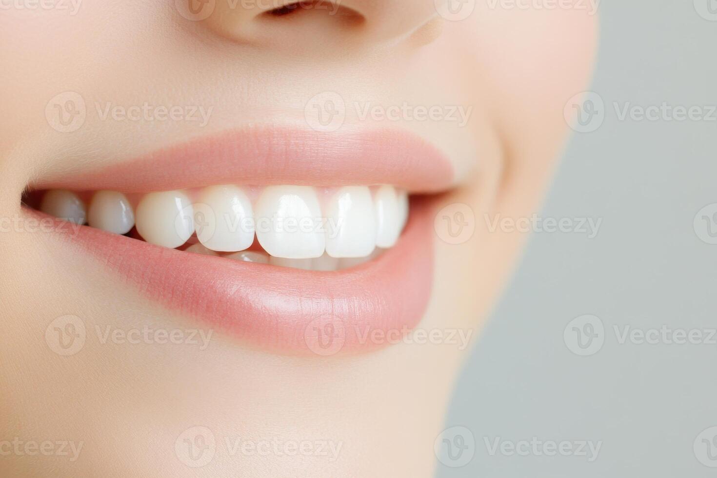Close up of a perfect smile, showing white teeth and healthy lips against a neutral background photo