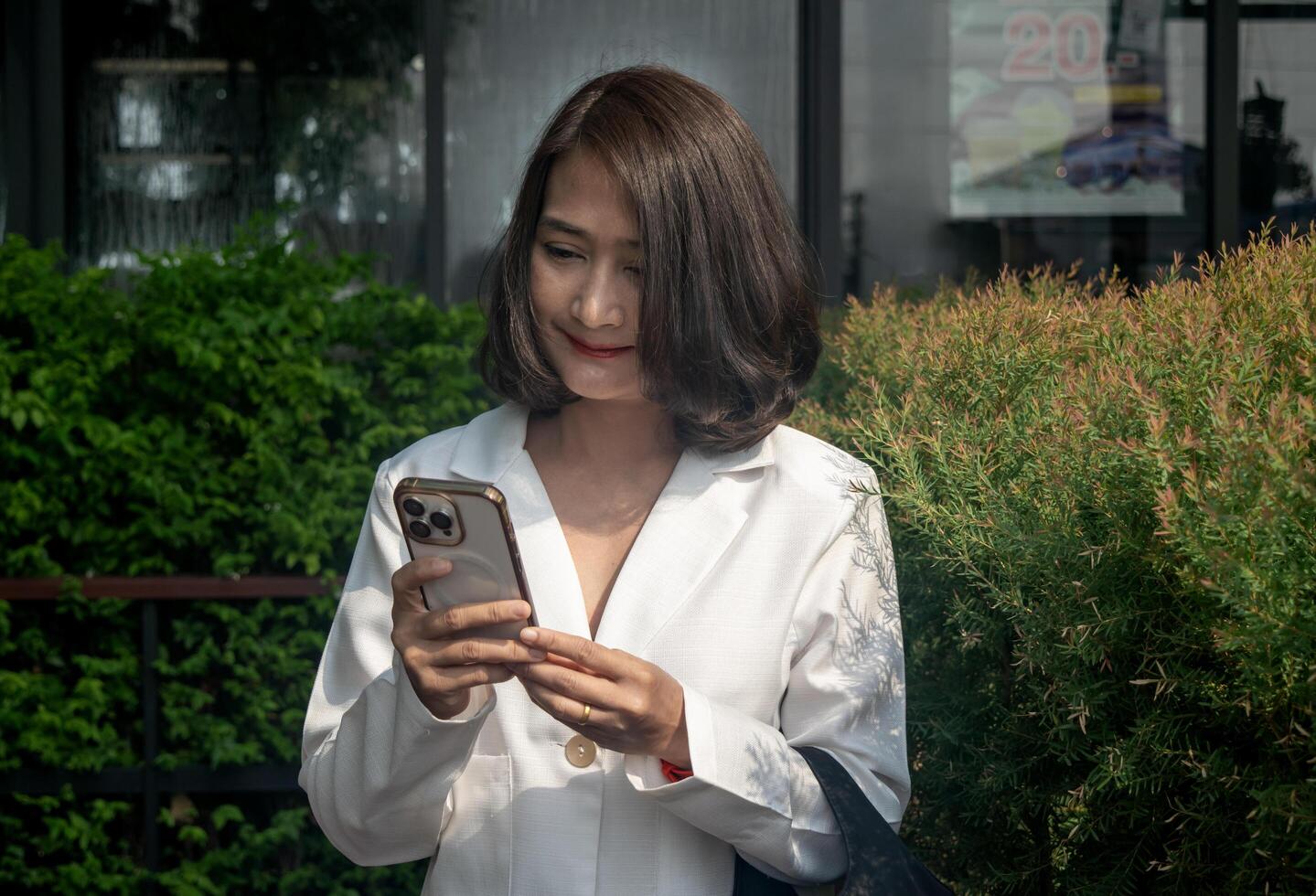 Businesswoman standing outdoor using smartphone send using texting message typing sms enjoying communication in mobile app photo