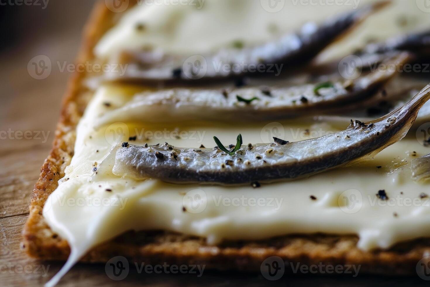 Anchovy fillets on creamy cheese cracker with herbs photo