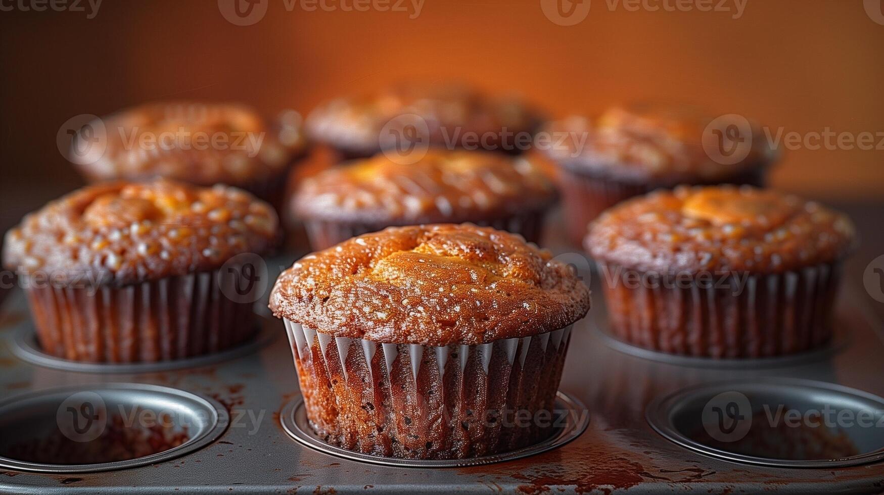 Freshly baked golden muffins in a tray with a warm and inviting glow photo