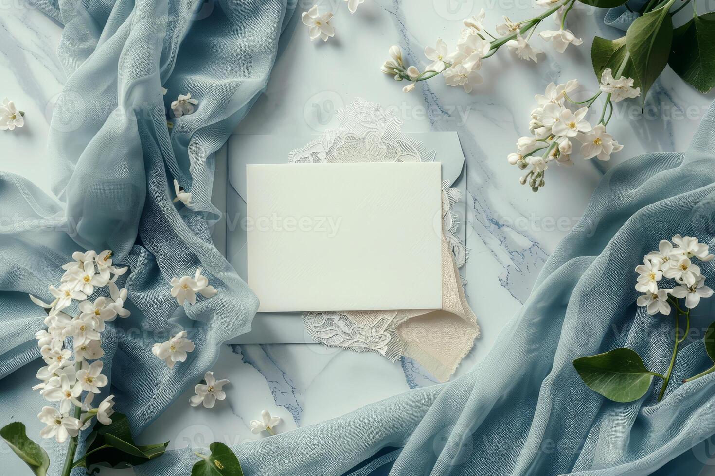 Flat lay arrangement showcases wedding invitation cards placed on a smooth surface with delicate flowers and fabrics, creating a serene and romantic atmosphere photo