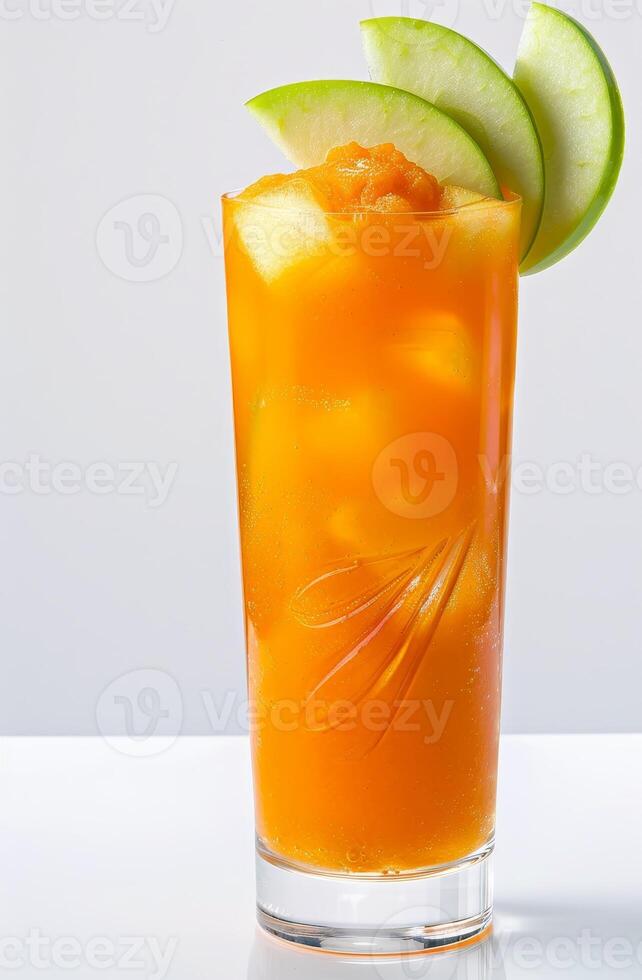 Bright orange carrot cocktail features ice cubes and green apple slices for garnish, beautifully displayed against a stark white background. Perfect for summer gatherings or health-conscious events photo