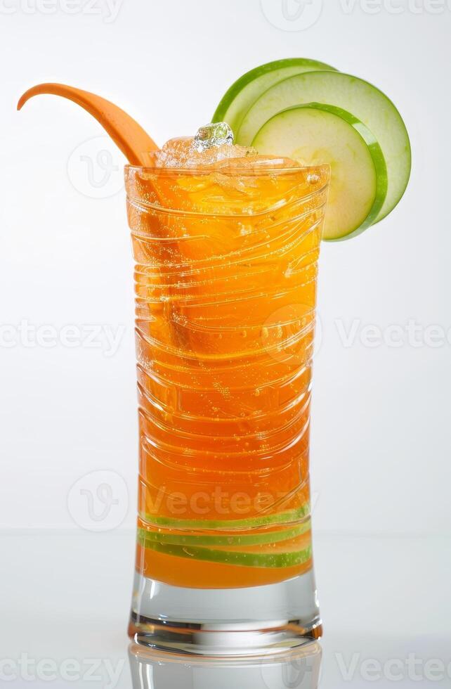 A vibrant carrot cocktail is presented in a tall glass, showcasing a colorful blend of orange and green. Fresh cucumber slices garnish the drink, adding an eye-catching detail photo
