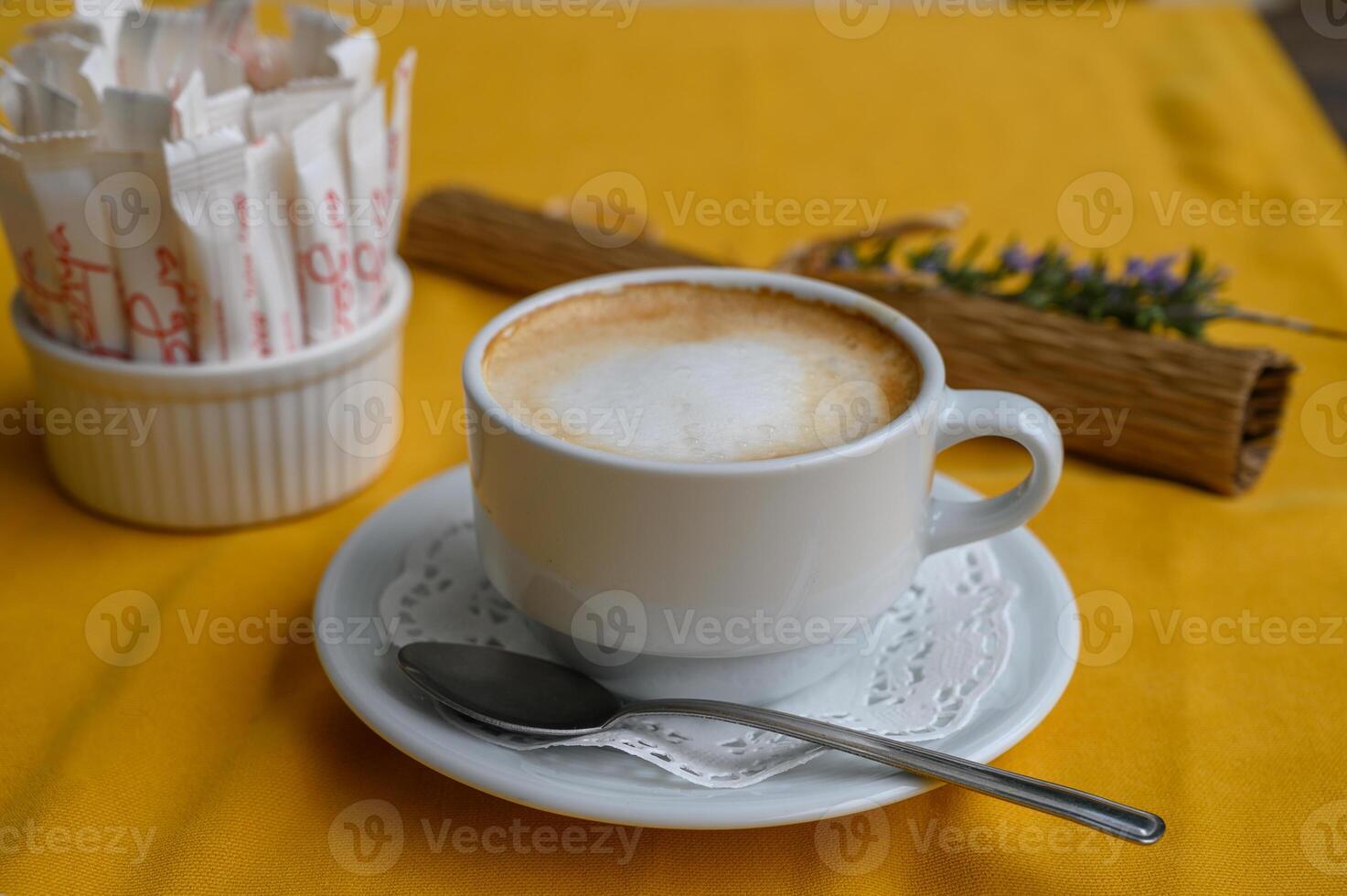 Enjoying a warm cup of coffee on a bright yellow tablecloth in a cozy cafe atmosphere photo