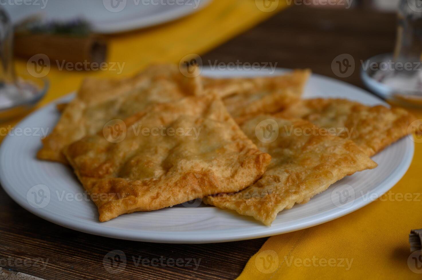 Delicious freshly fried pastries served on a white plate with a vibrant yellow tablecloth photo