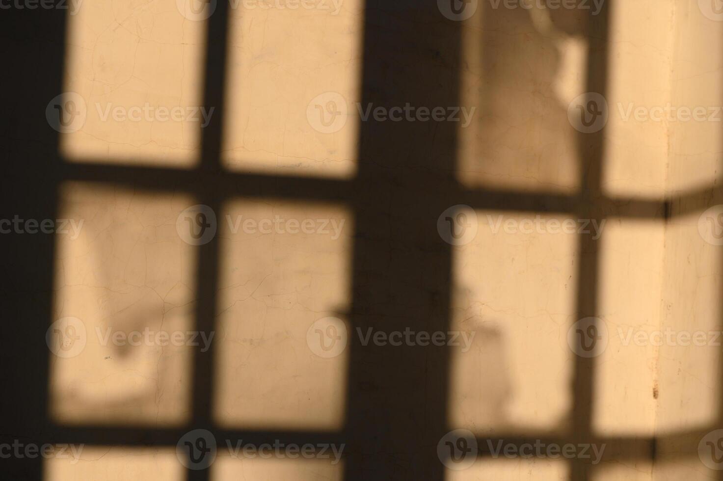 Shadows dance through a sunlit room, revealing textures of history and light play across the walls photo