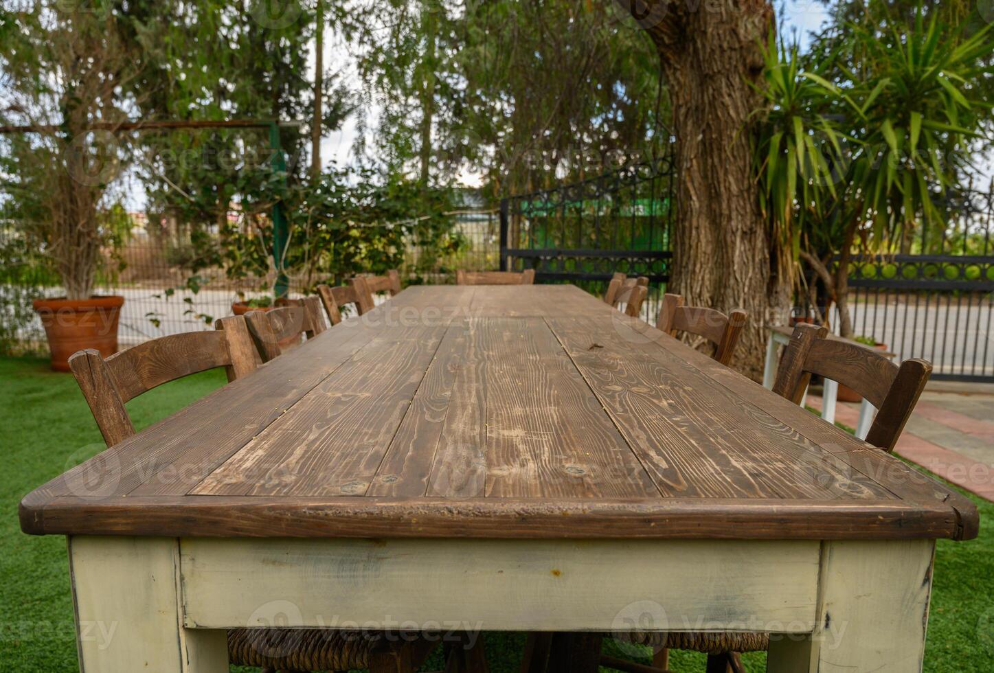 Long wooden table inviting gatherings in a serene outdoor setting photo