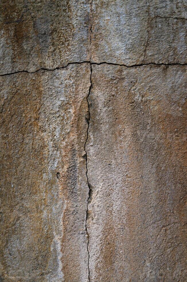 Cracked wall texture reveals layers of history in warm earthy tones photo