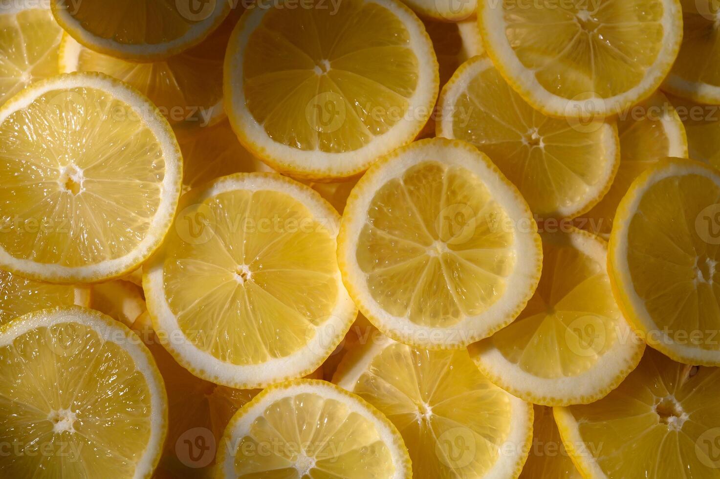 Bright yellow lemon slices arranged in a vibrant pattern create a refreshing and zesty visual delight photo