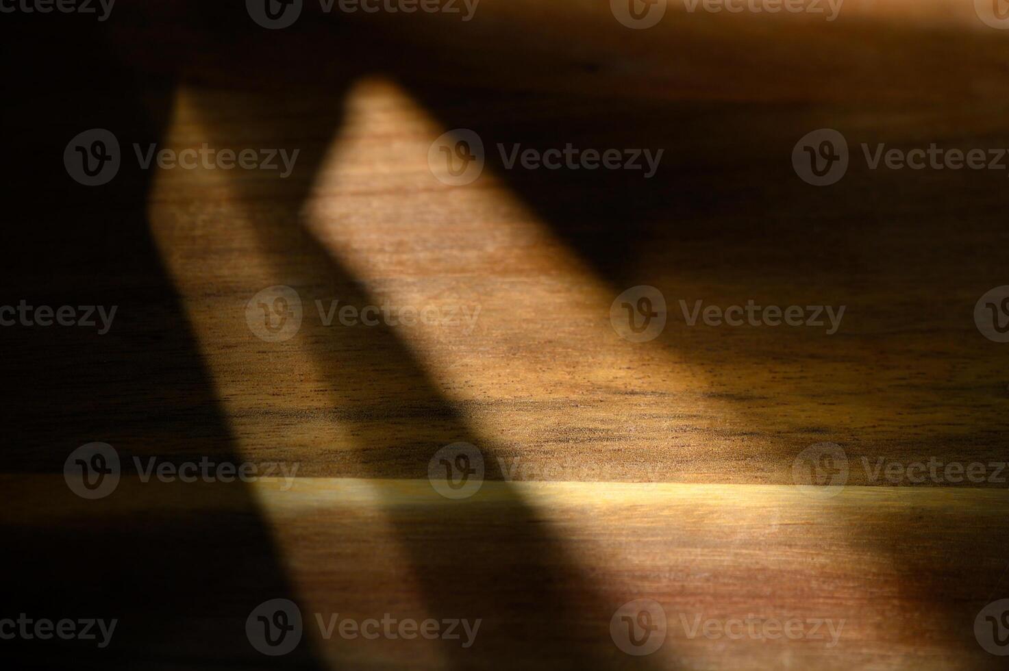 Play of light and shadow on a wooden surface creates a warm, textured ambiance during the afternoon photo