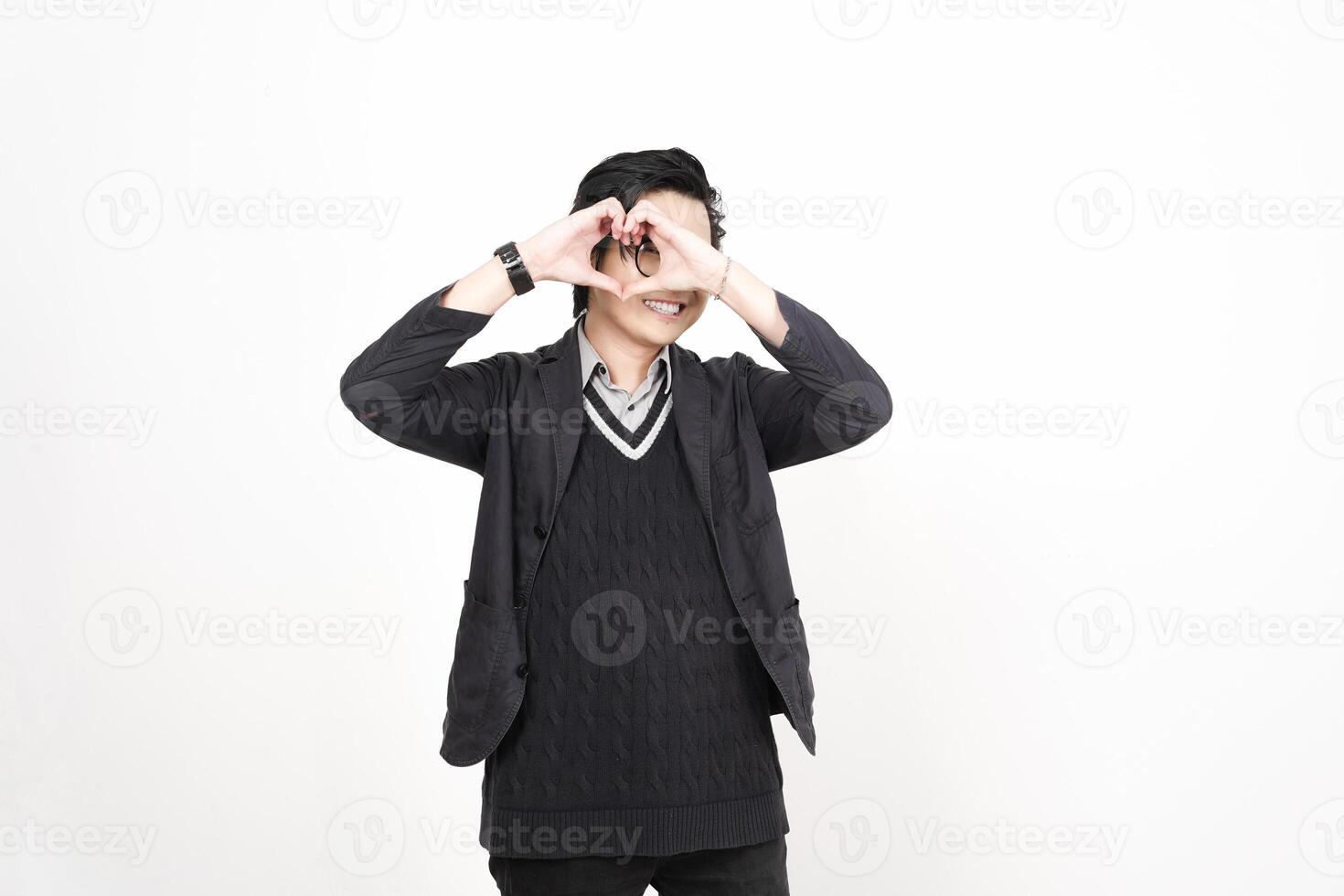 A man in a sweater and jacket making a heart shape with his hands photo