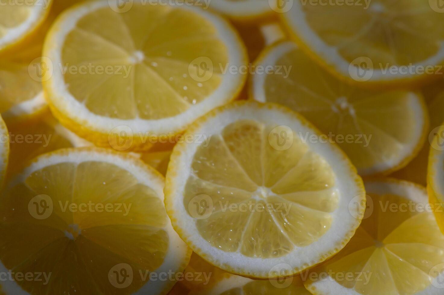Bright yellow lemon slices shimmering under soft sunlight, creating a vibrant display in a kitchen setting photo