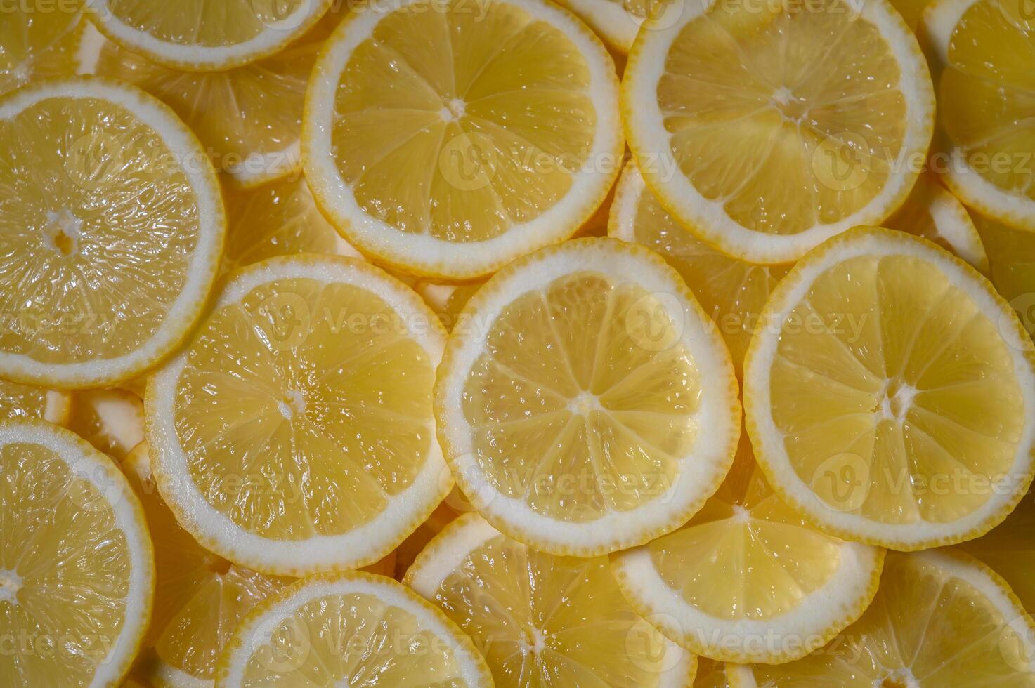 Freshly sliced lemons create a vibrant display of yellow on a sunny kitchen counter photo
