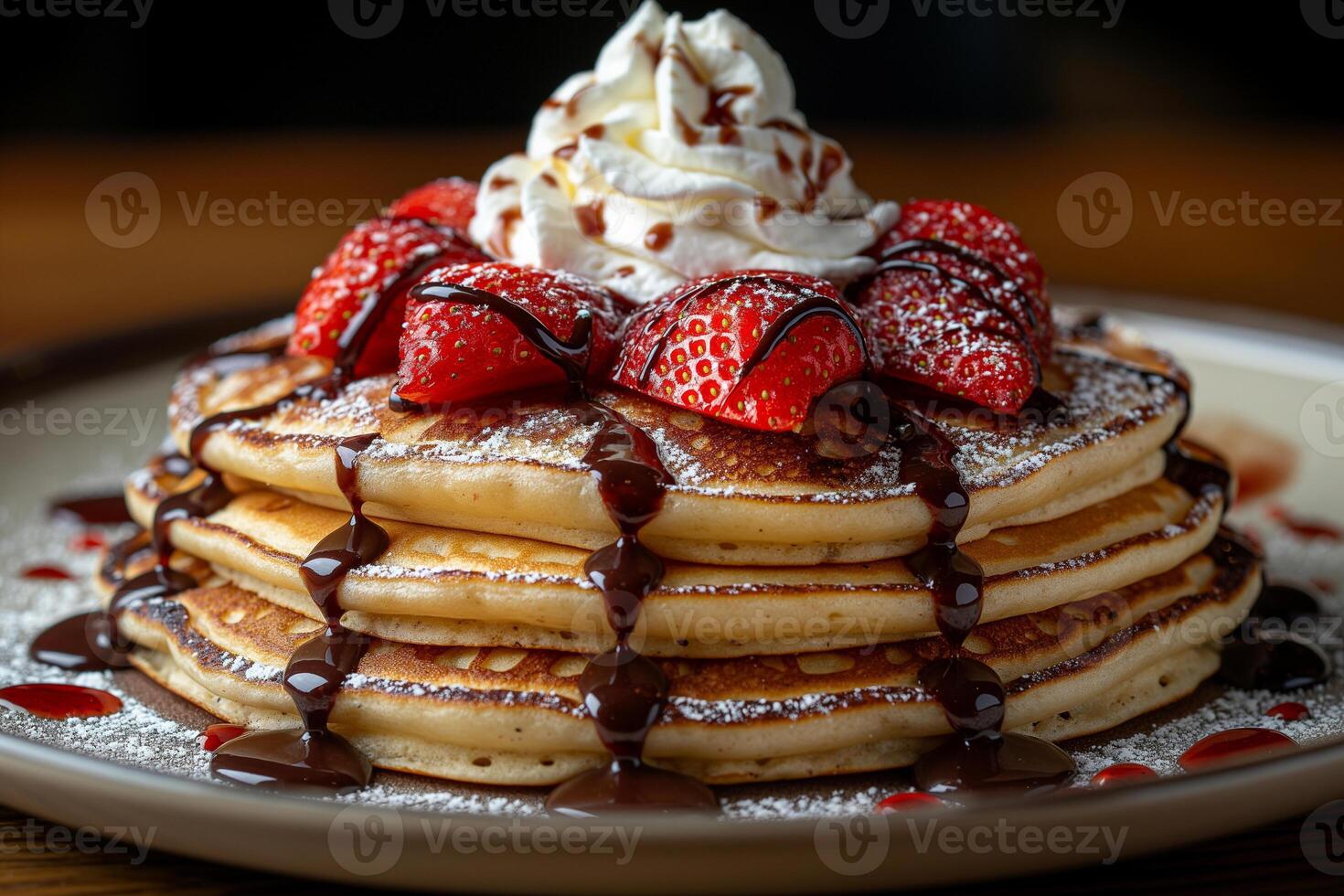 Indulgent stack of fluffy pancakes topped with strawberries and drizzled with chocolate syrup. photo