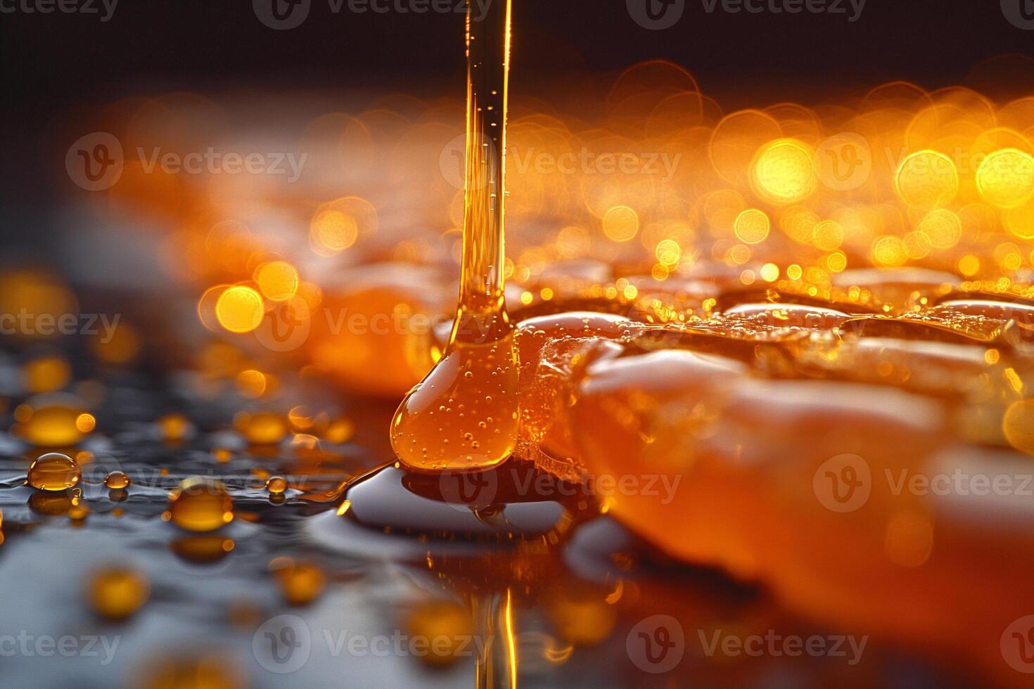 Golden syrup drips and glistens on a reflective surface during a warm afternoon. photo