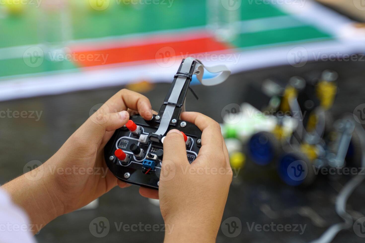 Asian students sit together with friends from the Robotics Club. Assemble the parts of a robot car. photo
