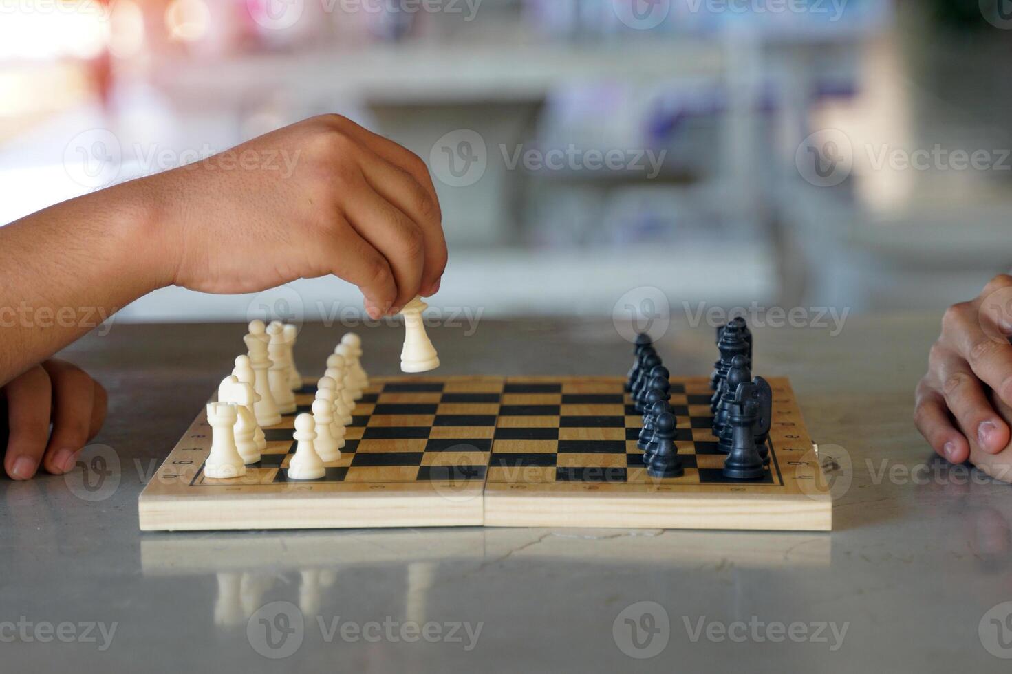 Close up of a chess player's hand moving pieces on the board as planned to defeat the opponent. Soft and selective focus. photo