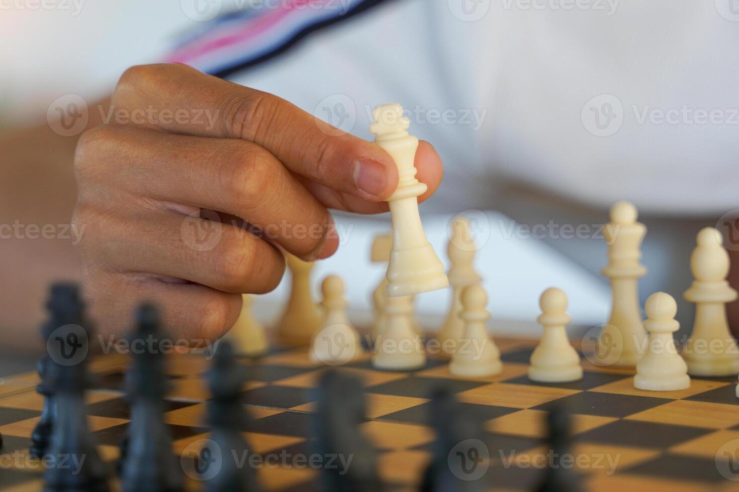 Close-up of a chess player's hand moving pieces on the board as planned to defeat the opponent. photo