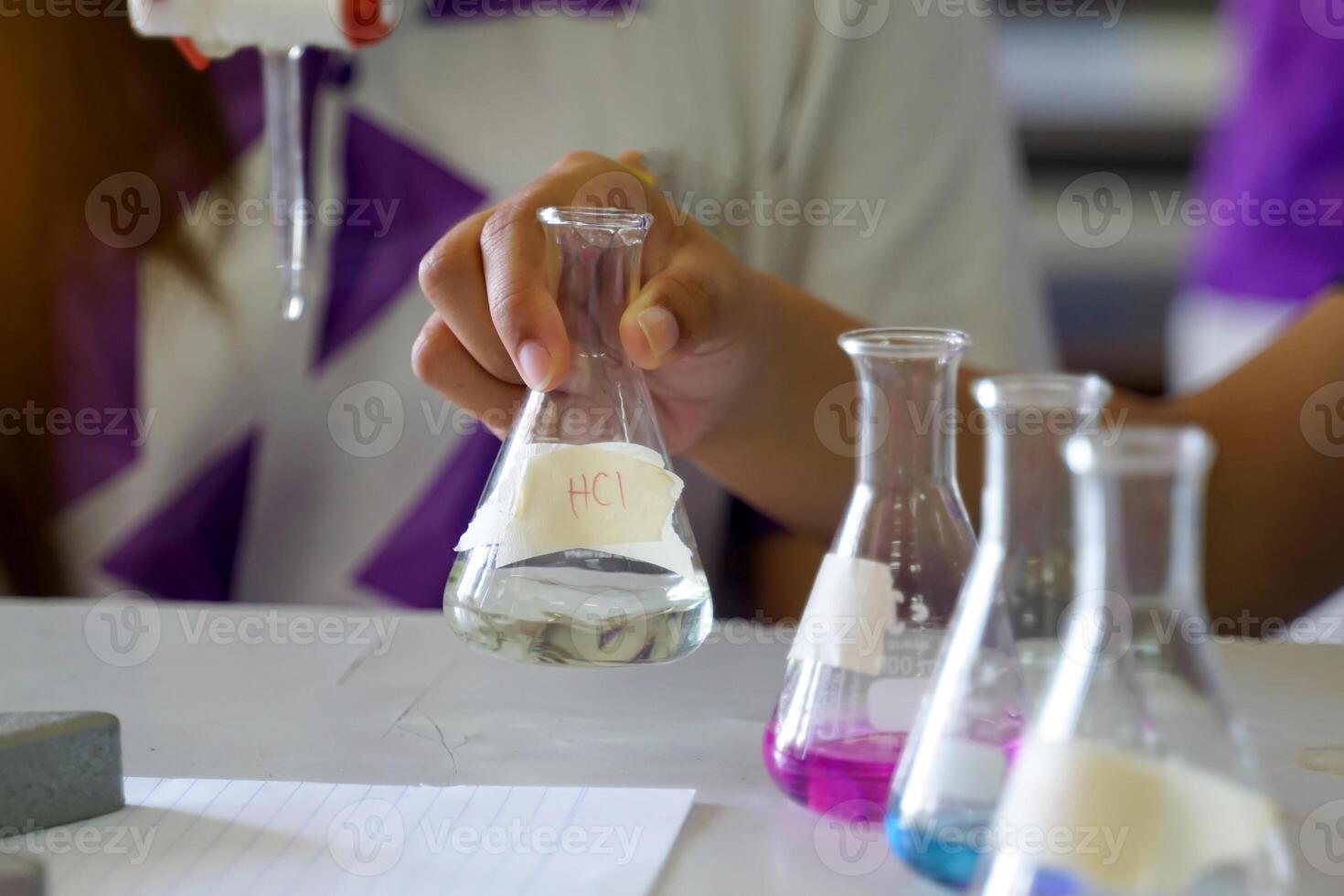 Close-up of student performing an acid-base titration experiment. Concept of chemistry lab, science, experiment, skills, learning. photo