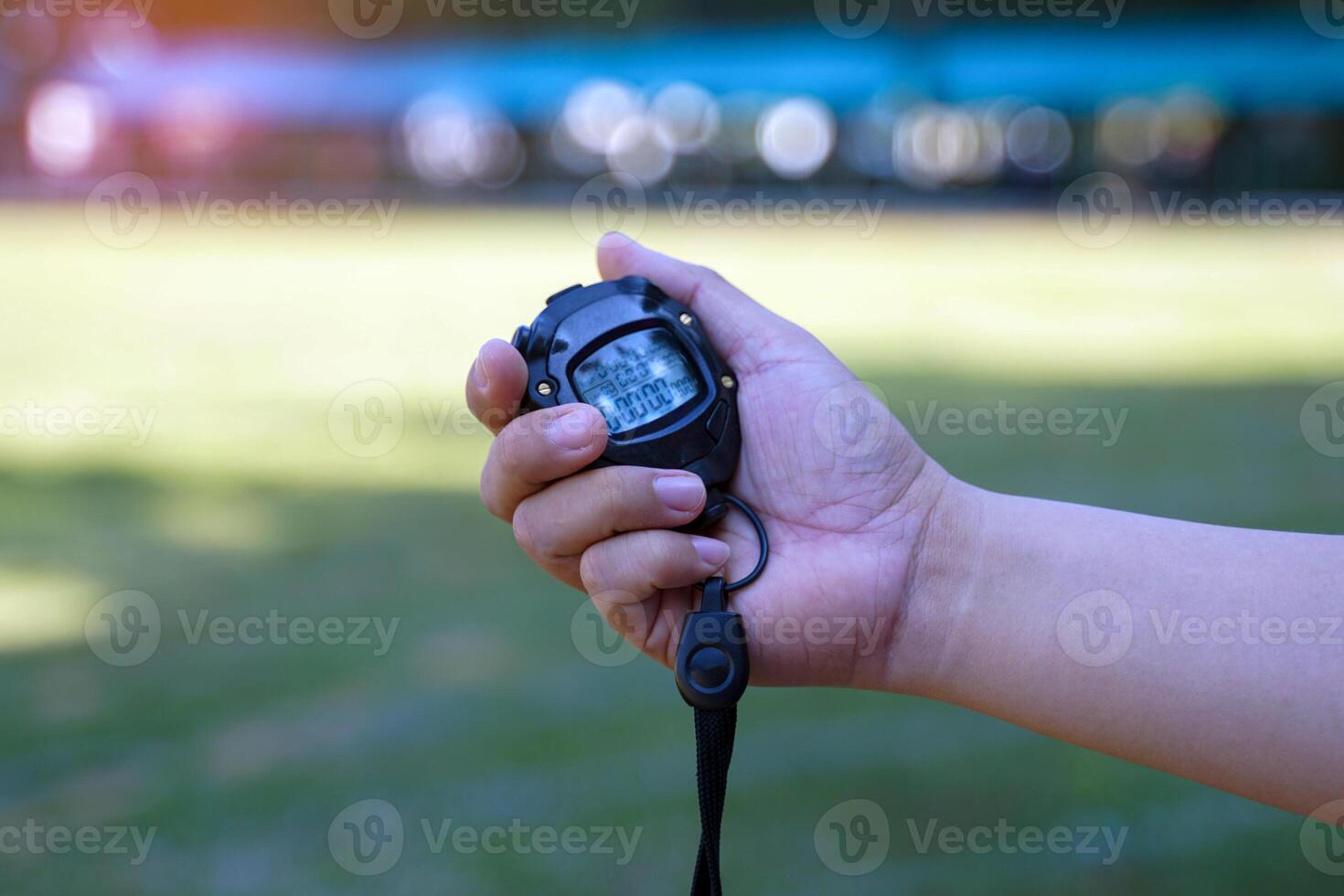 Coach holds a stopwatch to check the runners' speed statistics during practice. photo