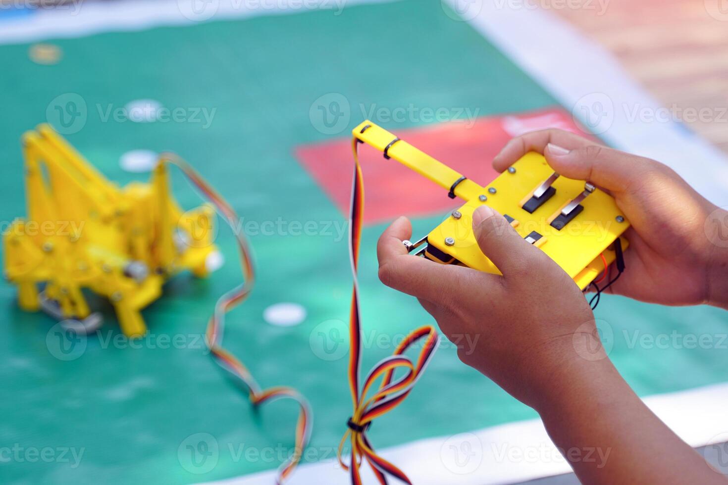 Asian students sit together with friends from the Robotics Club. Assemble the parts of a robot car. Soft and selective focus. photo