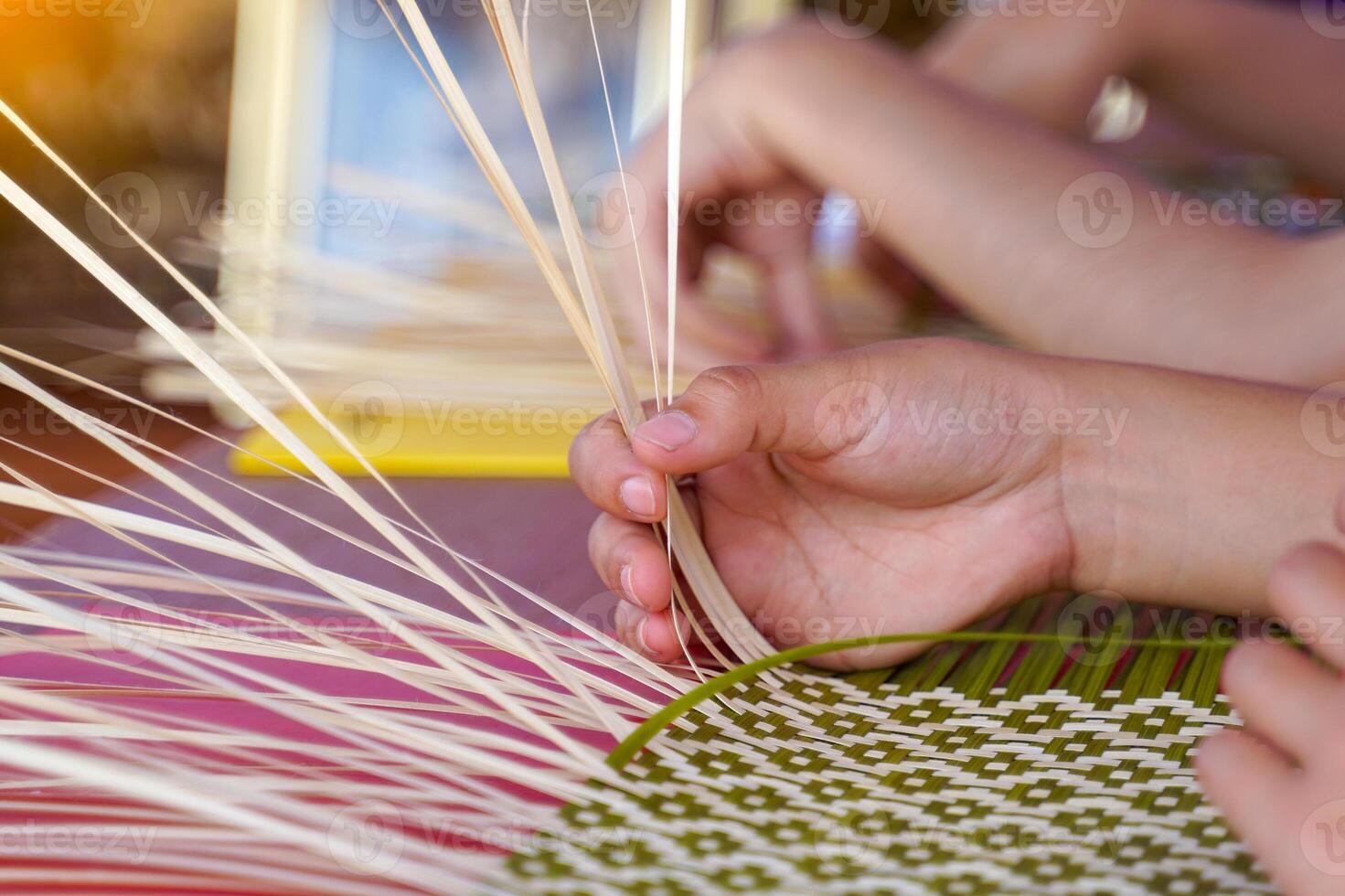 Students practice weaving bamboo baskets, a traditional Thai handicraft. photo
