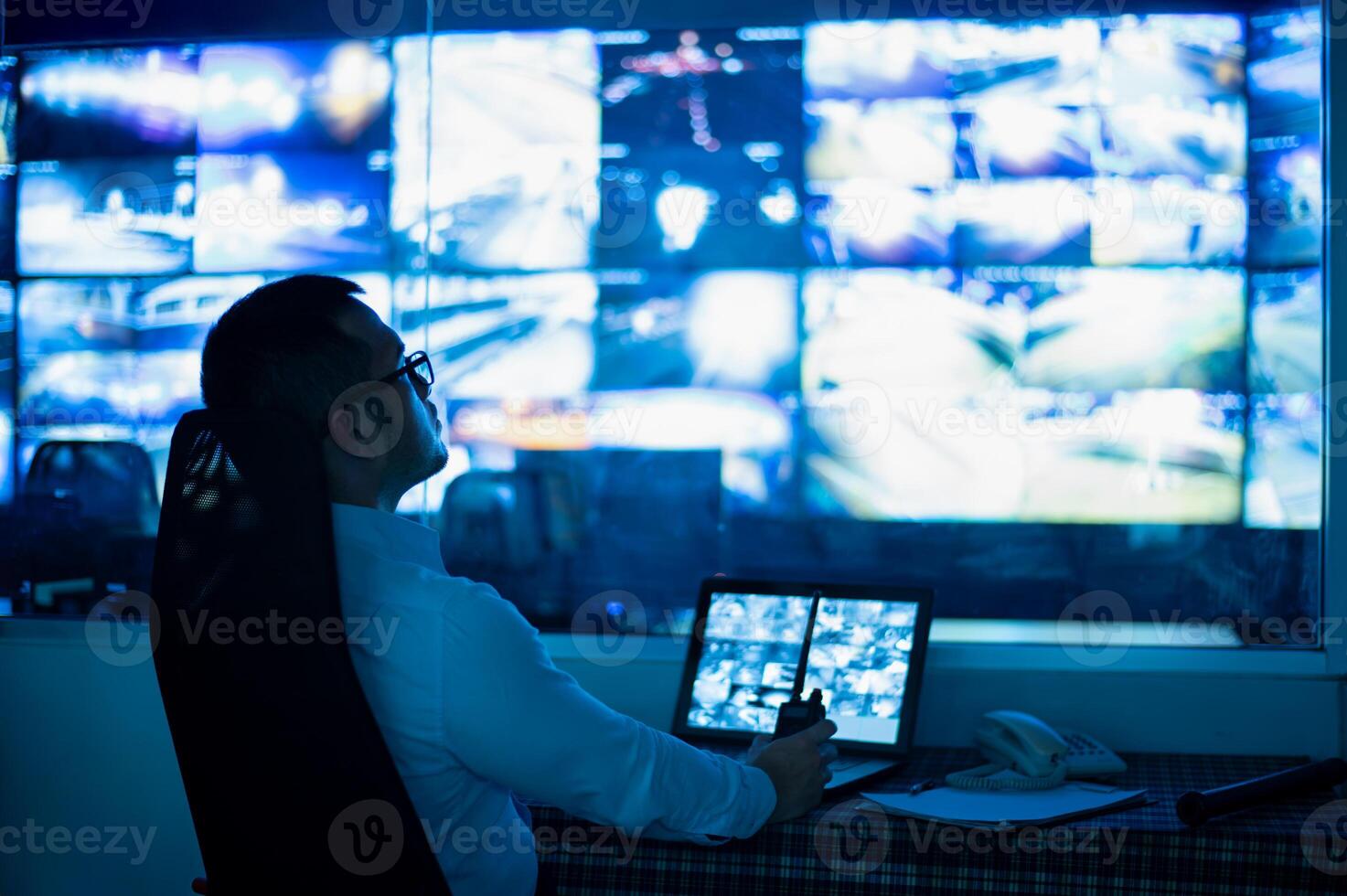 CCTV staff sat intently watching multiple monitors. photo