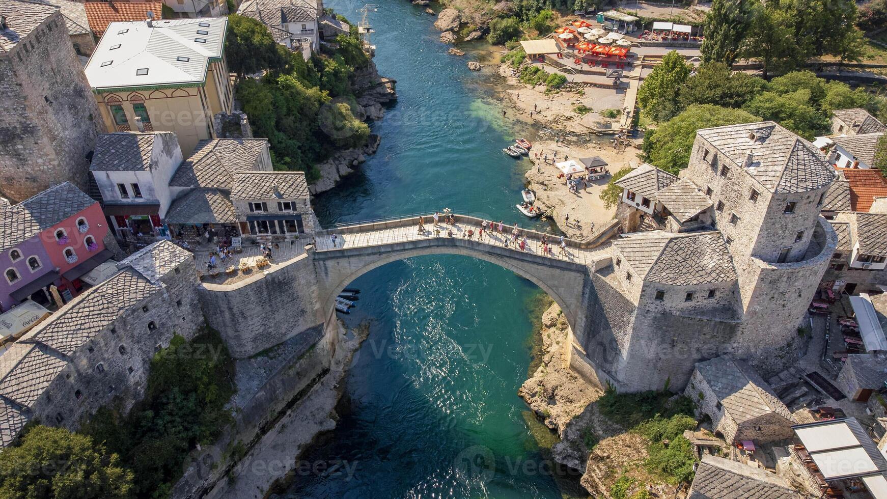 Top view of famous Mostar bridge. Aerial landscape view of tourist attraction with city background in summer photo