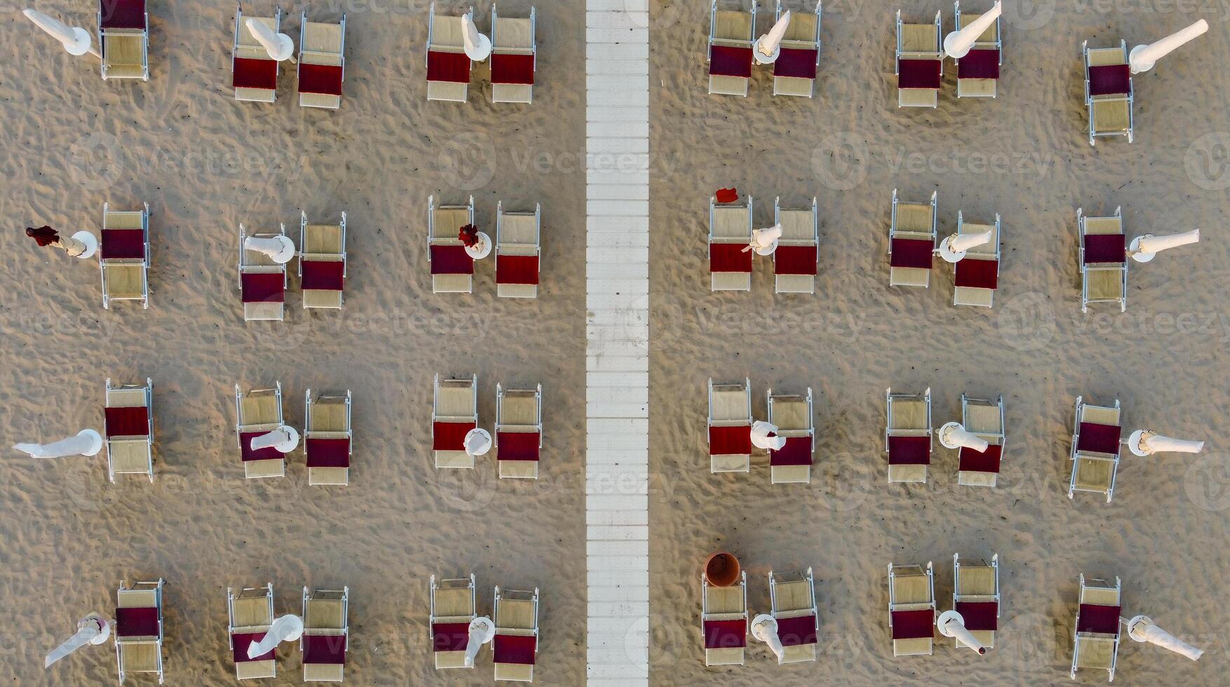 Top down view of closed umbrellas in the evening in summer at the beach of Marina di Ostuni, Puglia, Italy photo
