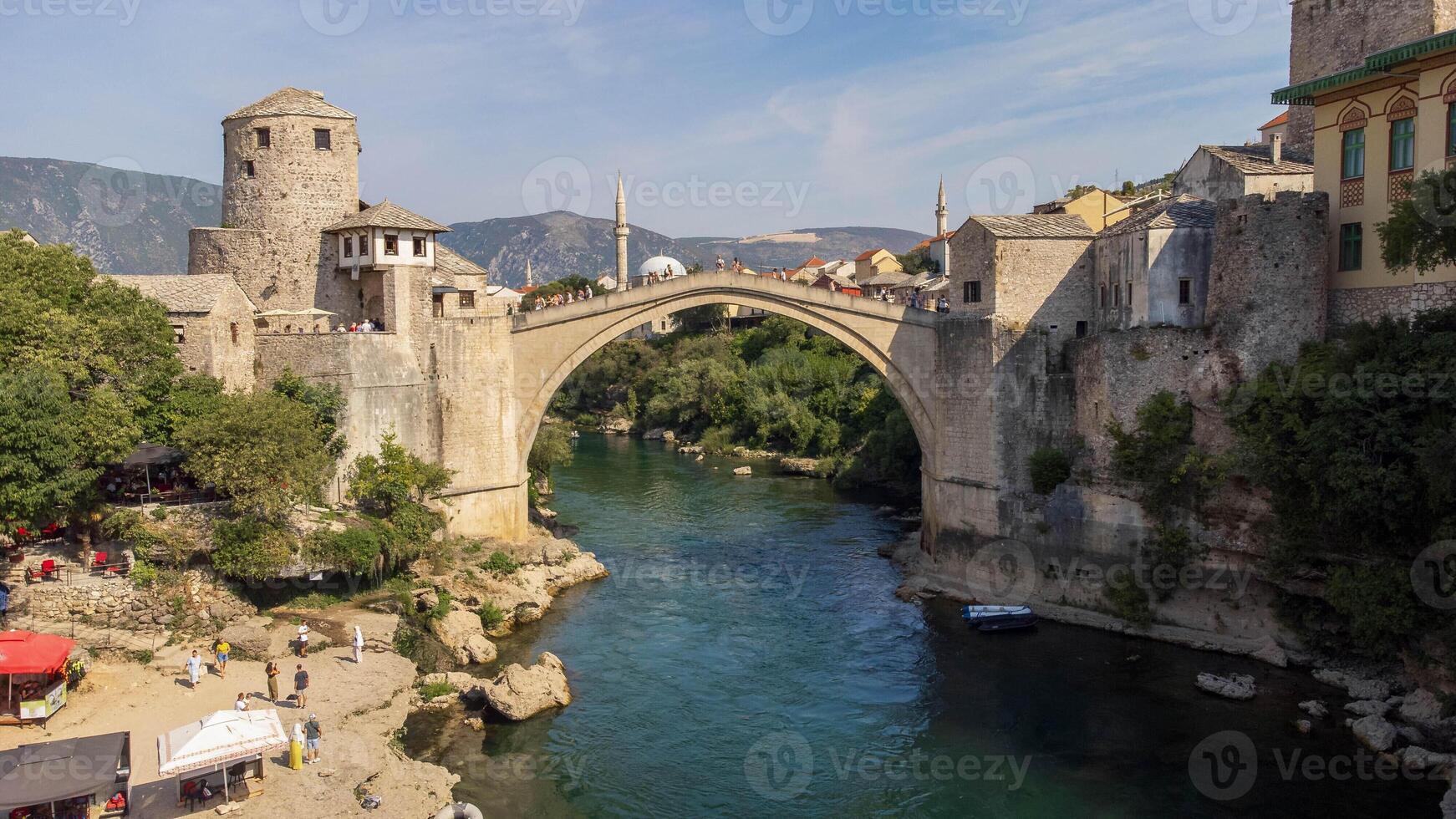 View of famous Mostar bridge. Aerial landscape view of tourist attraction with city background in summer photo