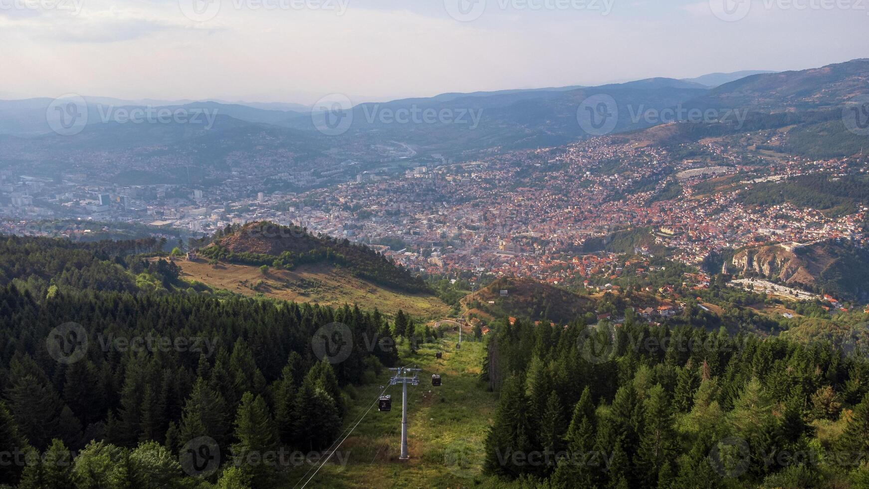 Aerial panoramic view of the city of Sarajevo with cable car, a tourist destination in Eastern Europe. View from a distance of the capital of Bosnia and Herzegovina in summer photo