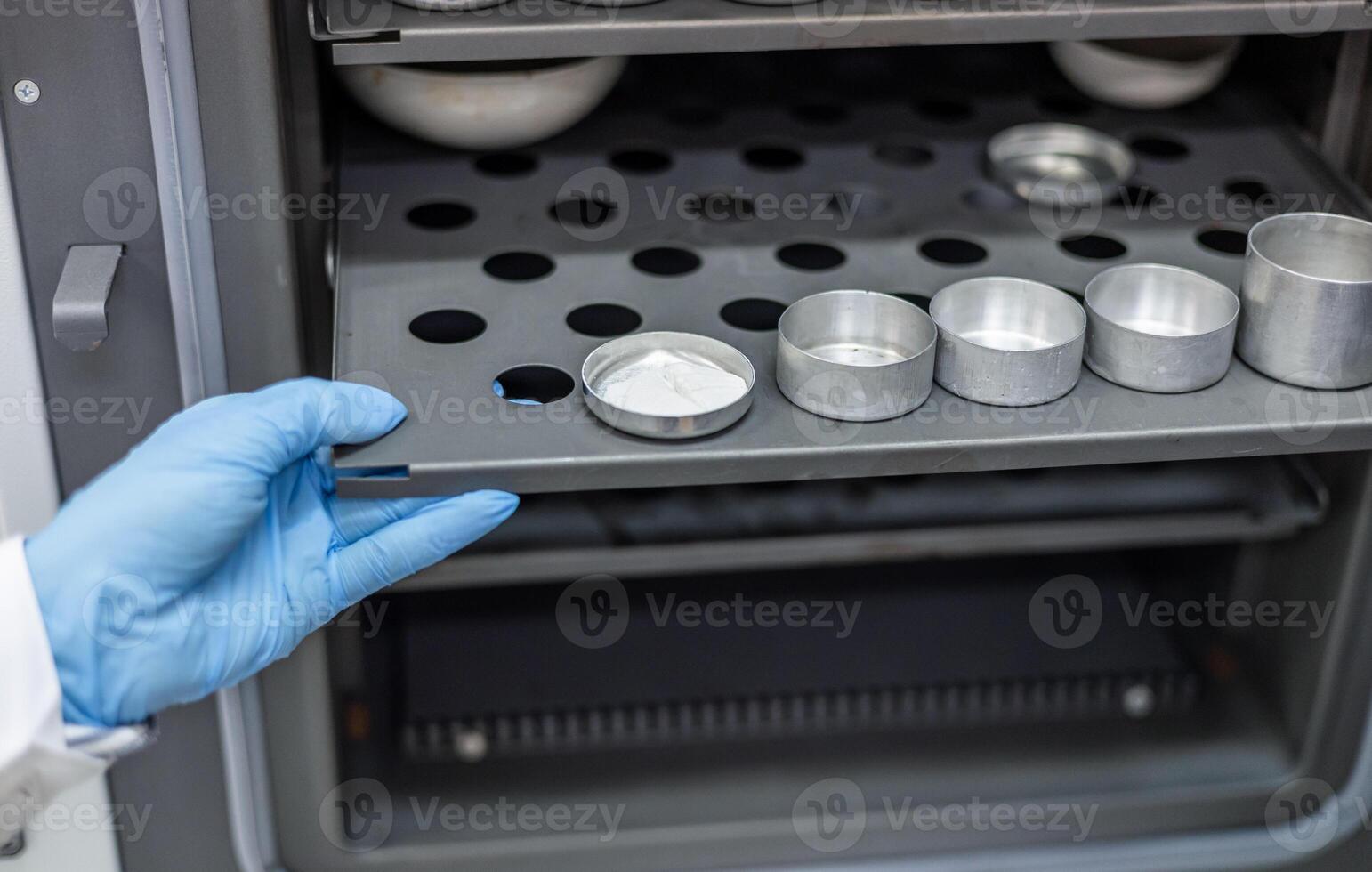 A person in a lab coat is holding a tray with some silverware photo
