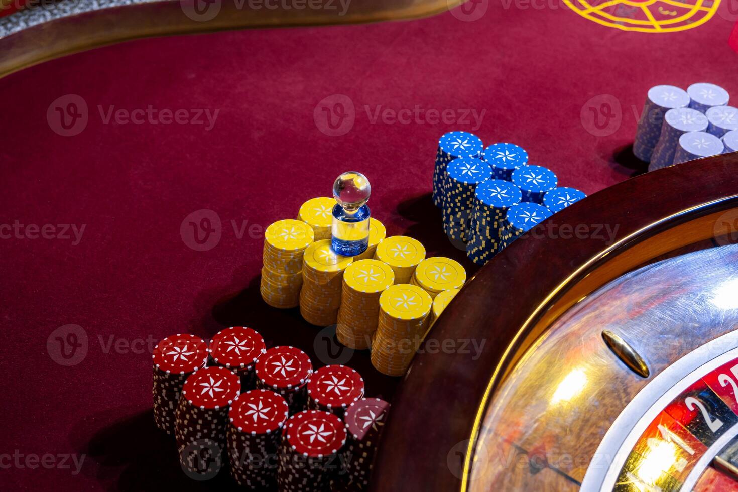A casino table with a roulette wheel and a bunch of chips photo