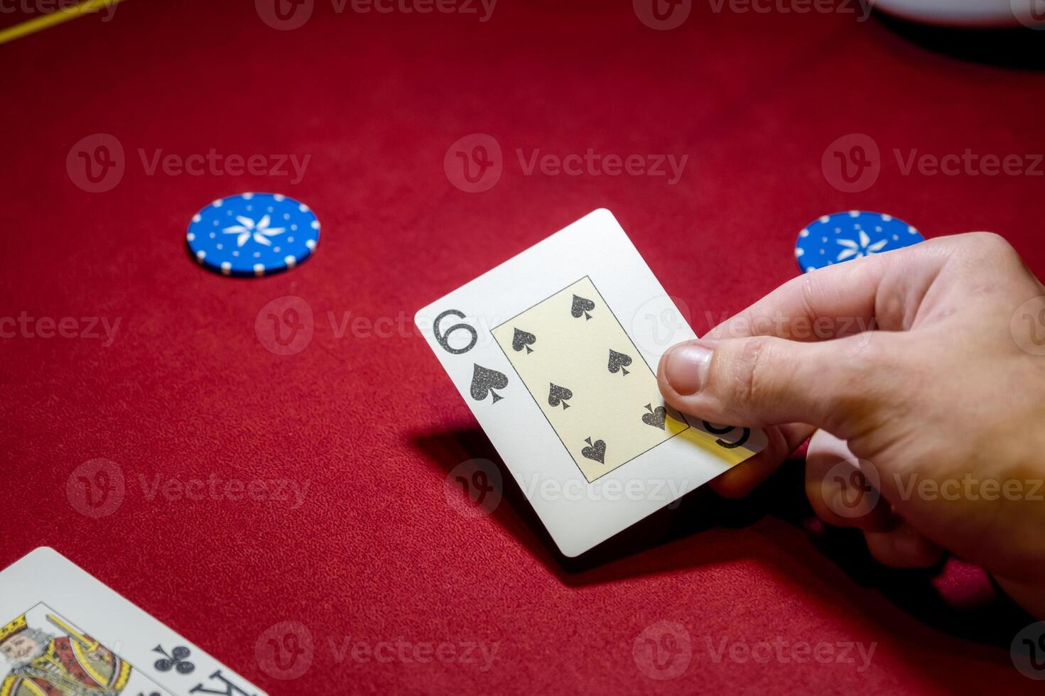 A person holding a card on a red table photo