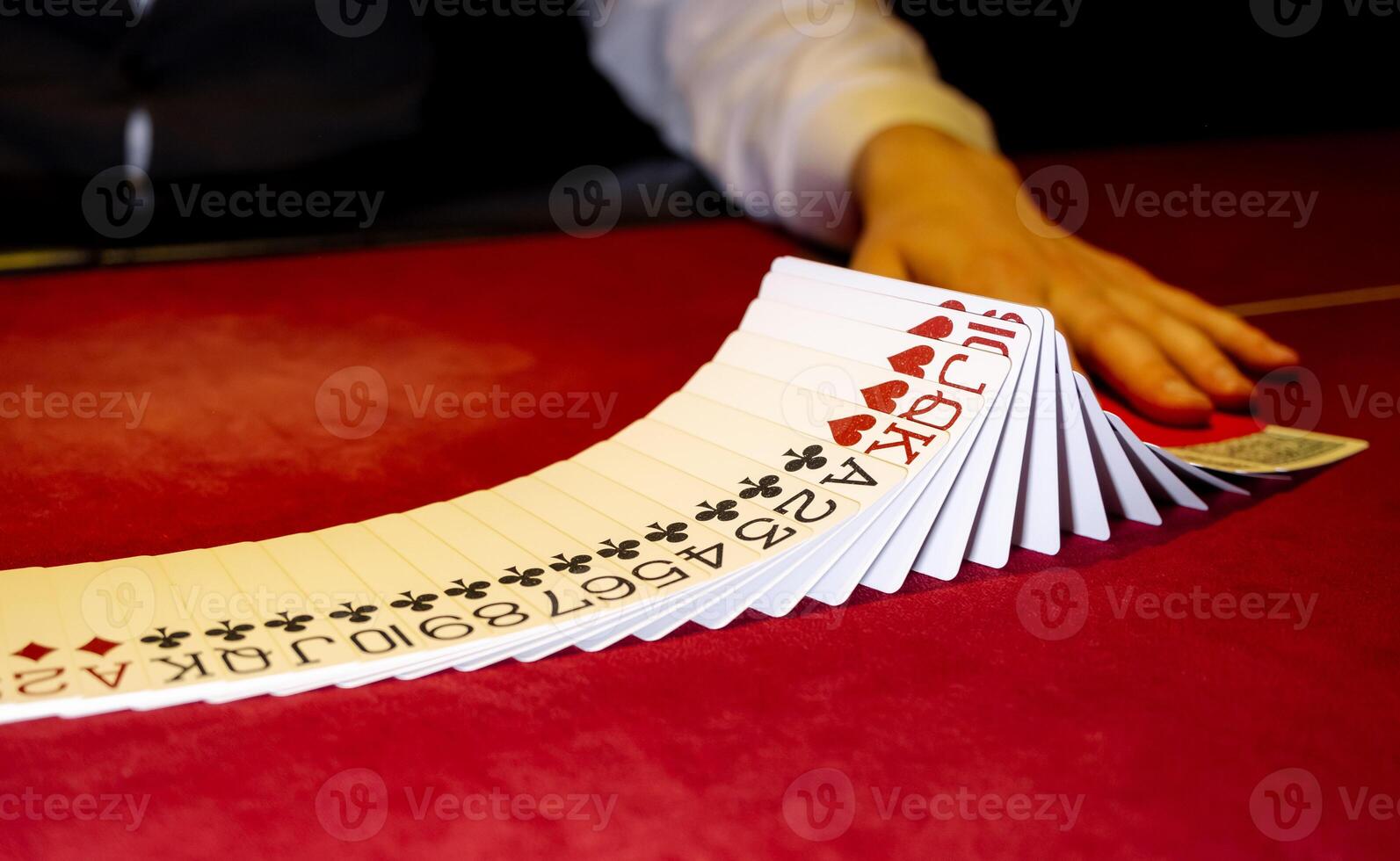 A person is holding a stack of cards on a table photo