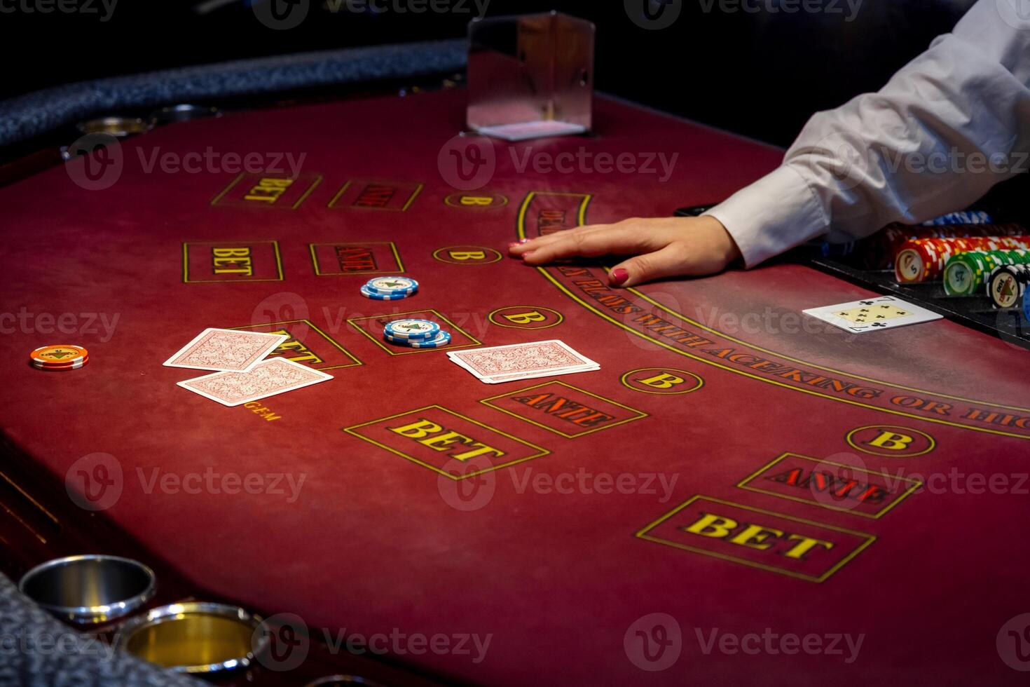 Casino. Black Jack card game. People play cards in a gambling establishment. Croupier hands dealing cards on t blackjack poker table, gambling table with cards and chips. photo