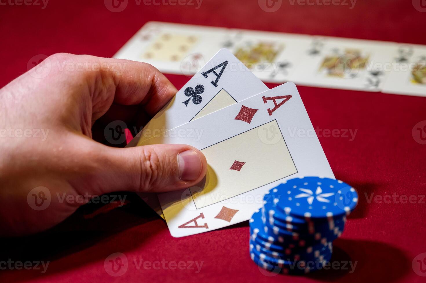 A person holding a pair of cards and a stack of chips photo
